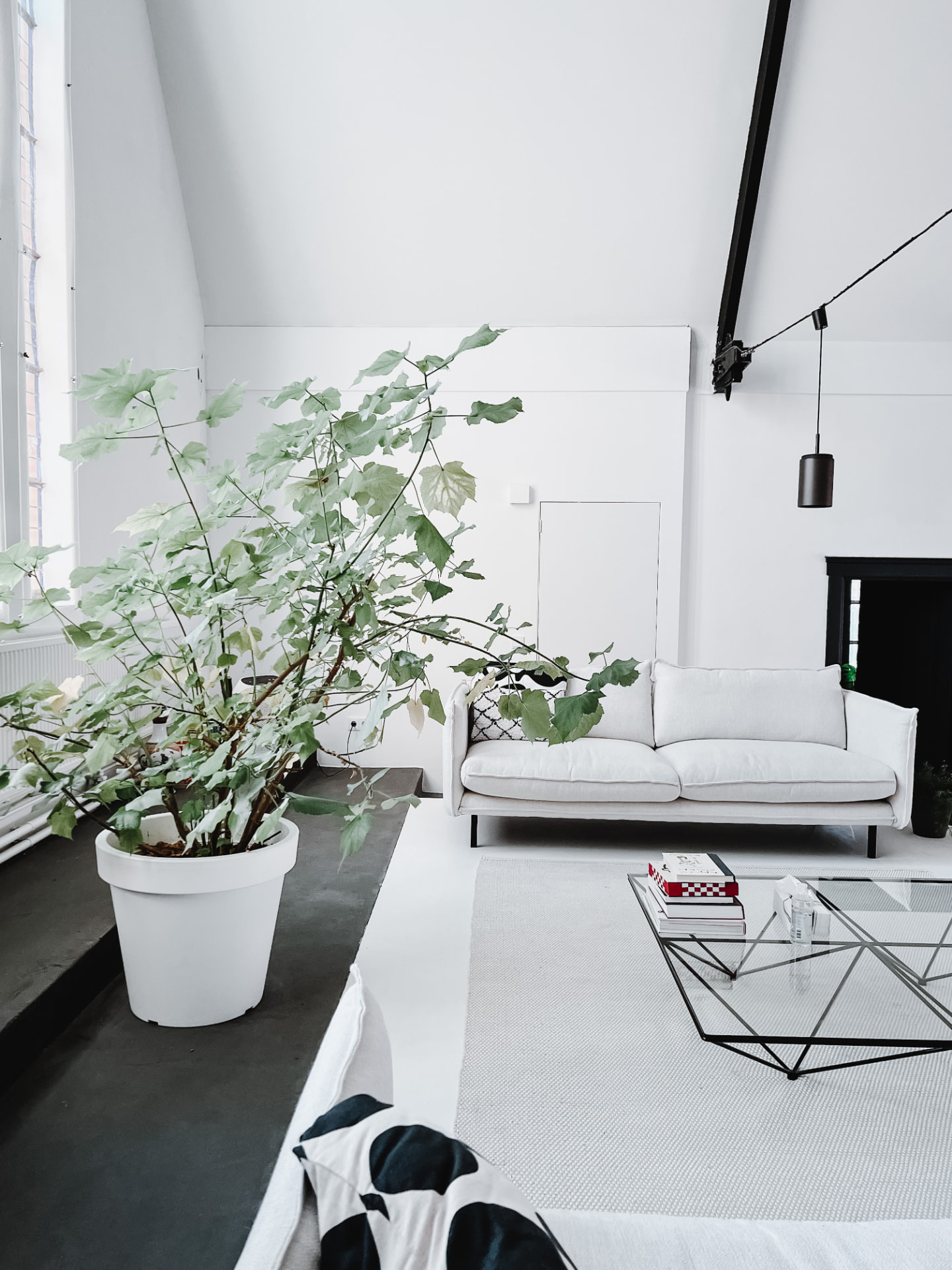Lichte hoek met witte bank in House of Meaning